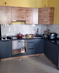 Черная угловая кухня в квартире-студии